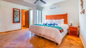 A bedroom with a bed, a ceiling fan, an air conditioning unit, and a nightstand. - Penthouse - Casa Mango Great location! (Isla Mujeres)