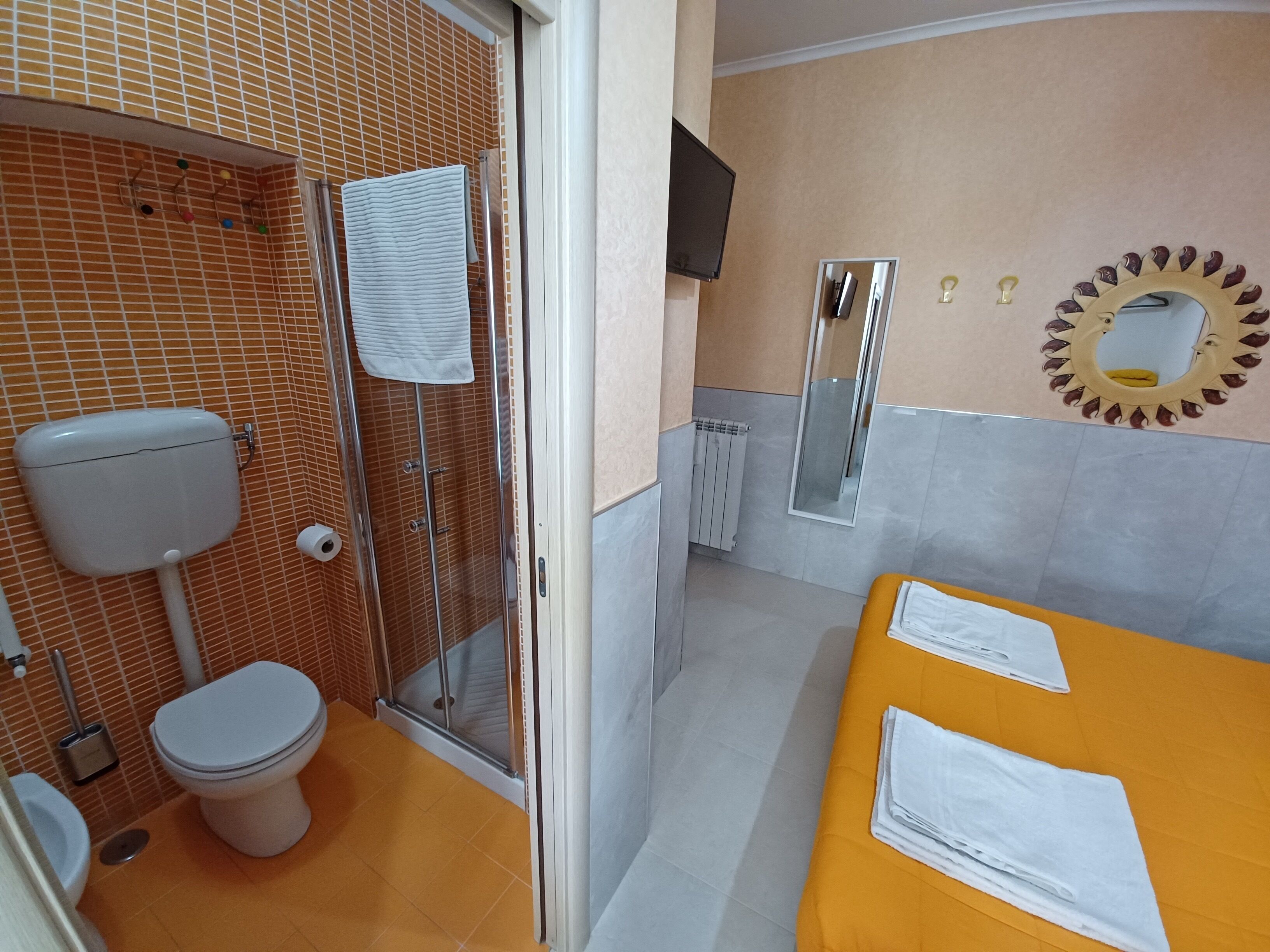 A bathroom with a toilet, shower, and sink.