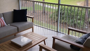 A balcony with a sofa, chairs, and a table. - Beautiful Condo in Tranquil, Tropical Setting in Flamingo Fairways 2 (Naples)