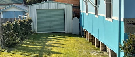A residential property with a garage, a fenced yard, and a house with a blue exterior.