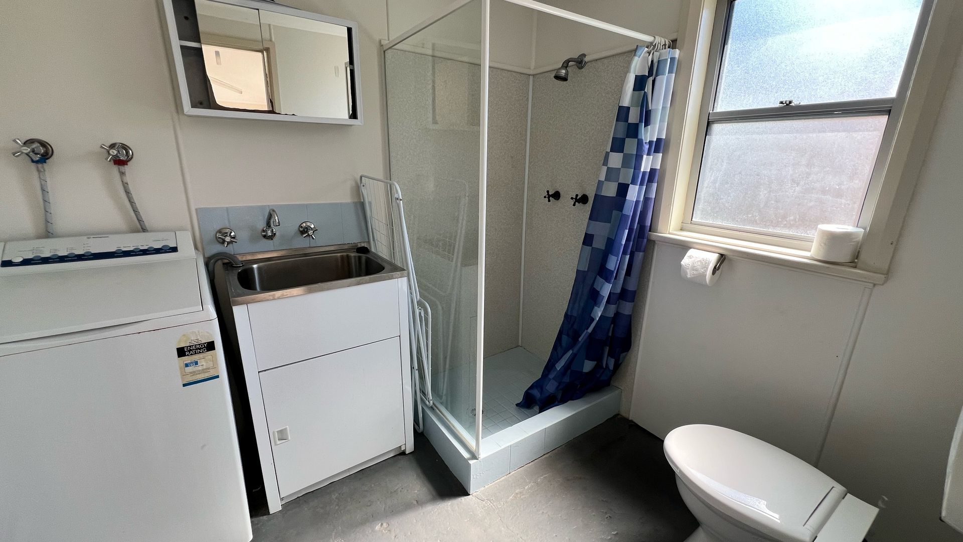 A bathroom with a shower, toilet, and sink.