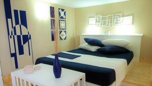 A bedroom with a bed, bedside tables, and wall art.