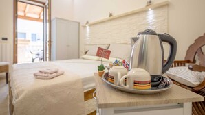 Une chambre d’hôtel avec un lit, un plateau contenant une bouilloire, des tasses et un panneau indiquant la présence d’un minibar.