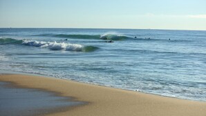 Une plage avec des vagues et des surfeurs.