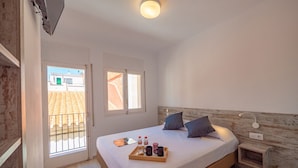 Een slaapkamer met een bed, nachtkastje en een dienblad met toiletartikelen.