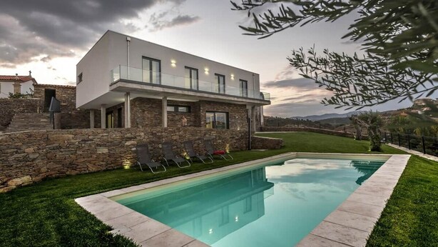 A modern house with a swimming pool, stone walls, and a grassy lawn. - Longra Family Villa & SPA (Mirandela)