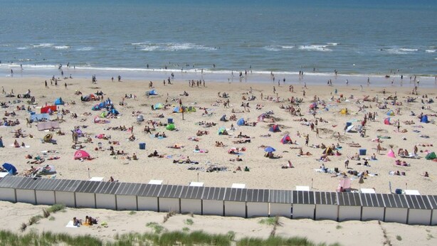 A beach with numerous tents and people.