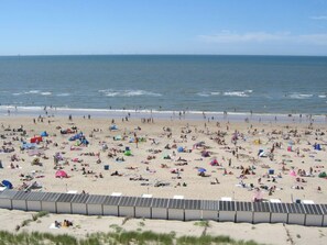 Una playa con muchas tiendas de campaña y gente.