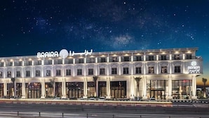 Een meerlaags hotel met een opvallend bord waarop 'BRAIRA HOTEL' staat.