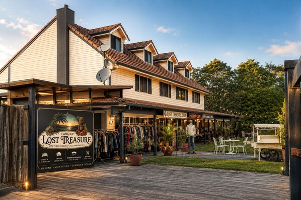 A boutique hotel with a signboard advertising 'Lost Treasure Boutique Holiday Accommodation' featuring 5-6 bedrooms, 4 indoor lounge areas, outdoor catering, and an exotic escape. - Land of Lost Treasure - Holiday House (Balmoral Ridge)