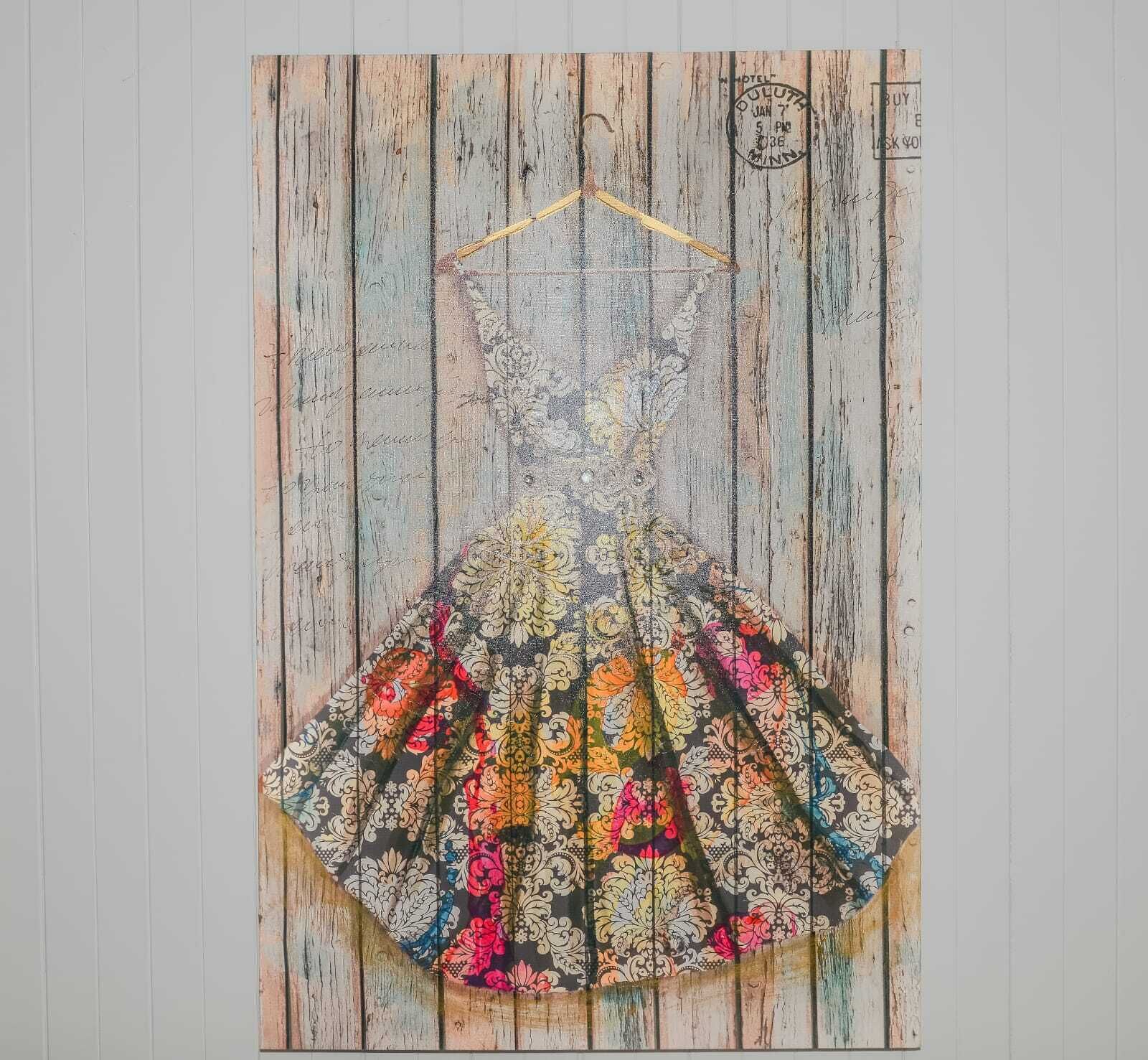 Un vestido antiguo colgado en una pared de madera.