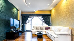 A modern living room with a sofa, a coffee table, and a TV on a stand.