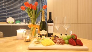 A table with a variety of food items, a bottle of wine, and a candle. - Hotel Prima (Busan)