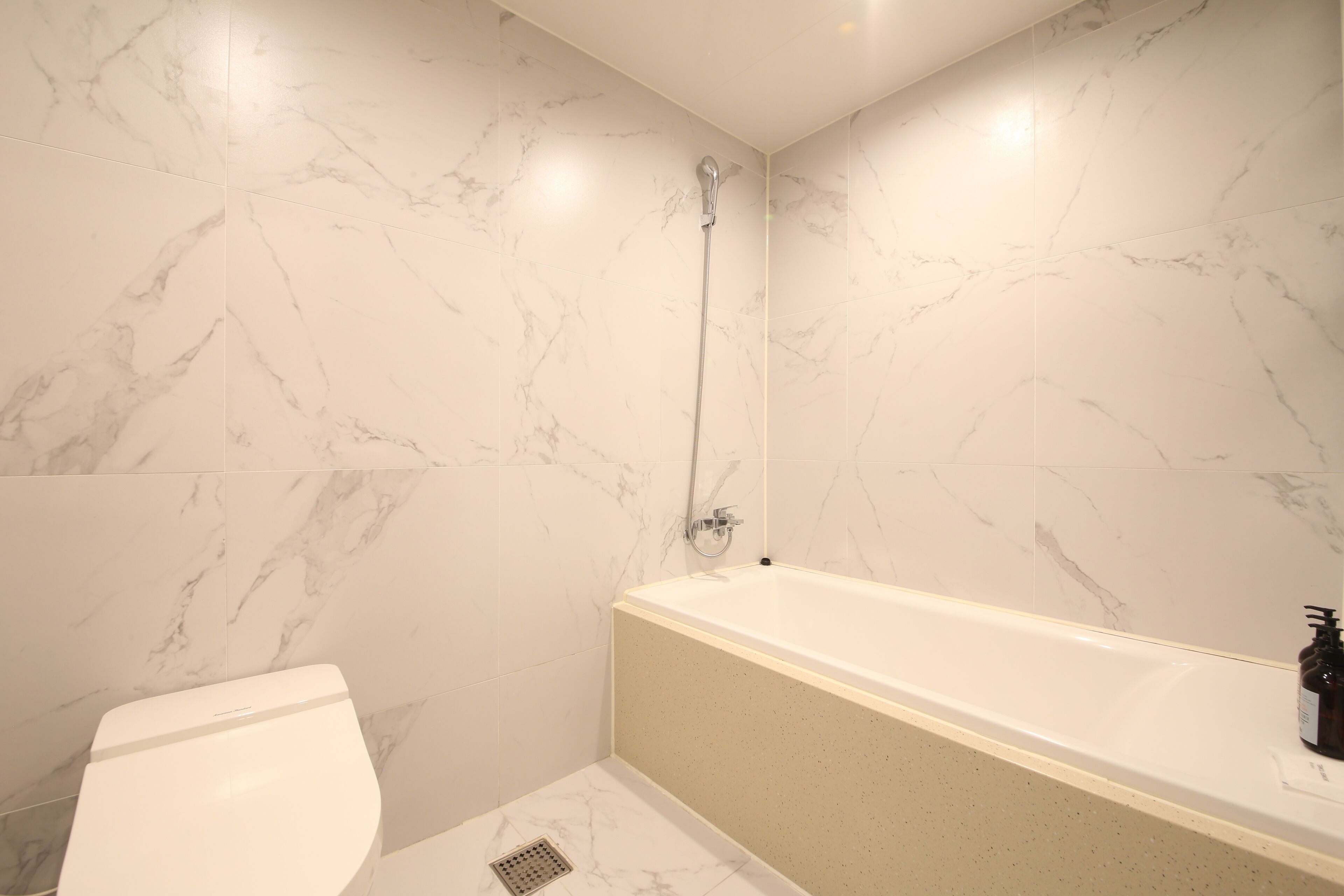 A bathroom with a white toilet, a bathtub, and a shower.