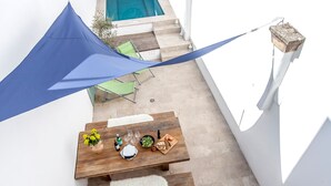 A wooden table set for dining with a pool in the background. - Cozy town house with private swimming pool (Pollença)