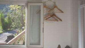 A bathroom with a window, an air conditioning unit, a towel rack, and a stone wall. - Separate air-conditioned bedroom, summer kitchen with steps and swimming pool (Sartène)