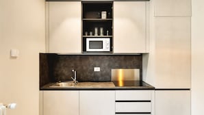 A compact kitchen with a built-in microwave, a stainless steel sink, and a black countertop backsplash. - GuestHost - Delightful apartment in a strategic position: close to the Ospedale Maggiore, 15 minutes by car from the center and close to public transportation. In the immediateneighborhood you can find restaurants, bars, supermarket and pharmacy.The apar (Bologna)
