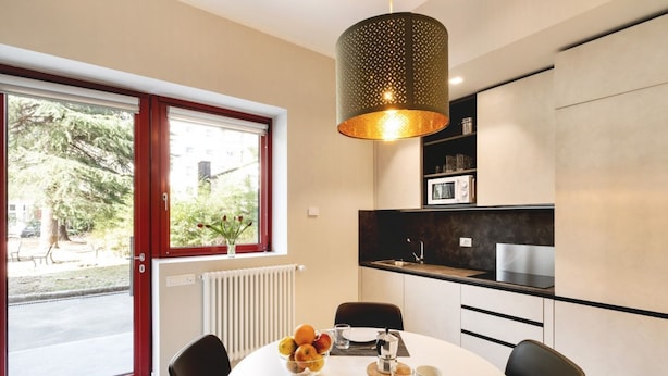 A modern kitchen with a dining area, a large window, and a hanging light fixture. - GuestHost - Delightful apartment in a strategic position: close to the Ospedale Maggiore, 15 minutes by car from the center and close to public transportation. In the immediateneighborhood you can find restaurants, bars, supermarket and pharmacy.The apar (Bologna)
