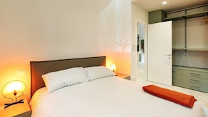 A bedroom with a bed, bedside lamps, a wardrobe, and a closet. - GuestHost - Delightful apartment in a strategic position: close to the Ospedale Maggiore, 15 minutes by car from the center and close to public transportation. In the immediateneighborhood you can find restaurants, bars, supermarket and pharmacy.The apar (Bologna)