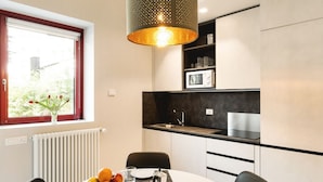 A modern kitchen with a dining area, a window with a view, and a decorative light fixture. - GuestHost - Delightful apartment in a strategic position: close to the Ospedale Maggiore, 15 minutes by car from the center and close to public transportation. In the immediateneighborhood you can find restaurants, bars, supermarket and pharmacy.The apar (Bologna)