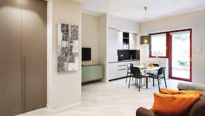 Een moderne keuken met een eethoek, een televisie en een groot raam.