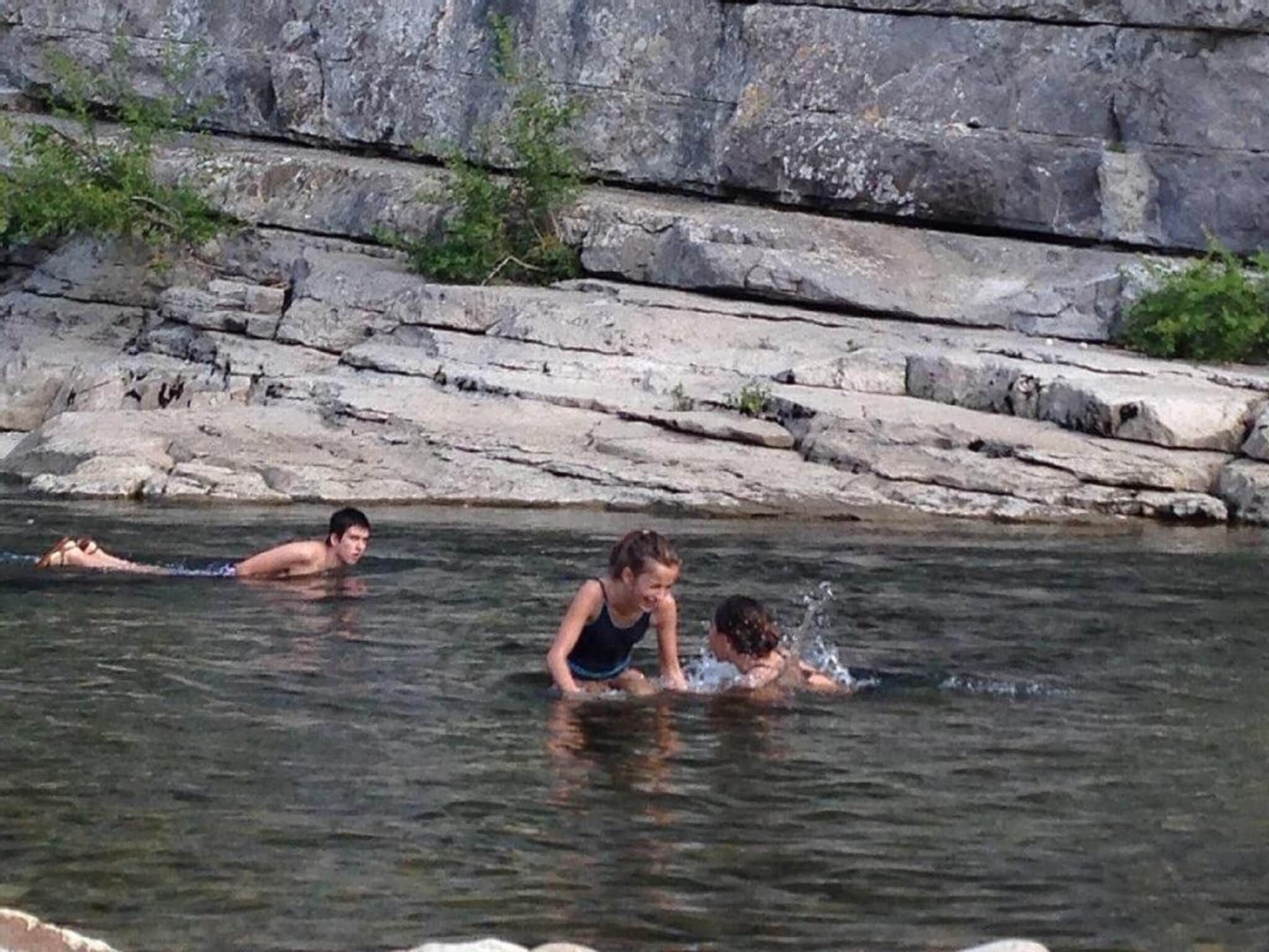 Een natuurzwembad met rotsachtige omgeving en helder water.