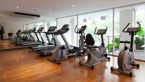 Et fitnesscenter med flere løbebånd, motionscykler og crosstrainere.
