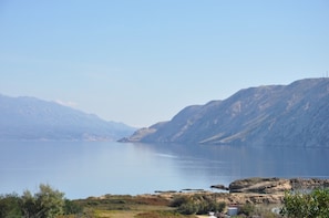 A serene lake with mountains in the background and a clear sky.