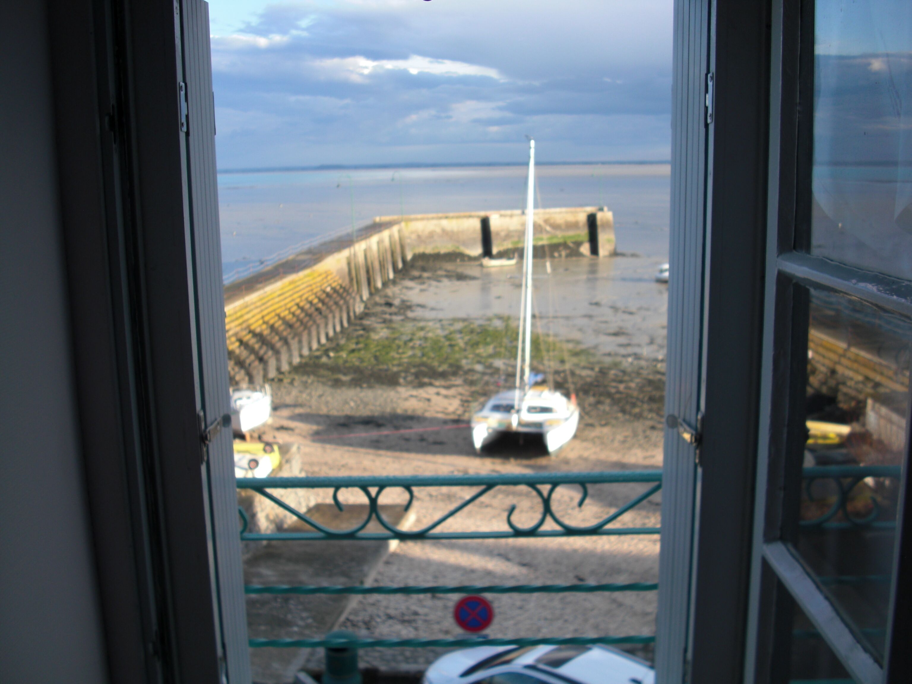 A view of a beach with a boat and a breakwater.