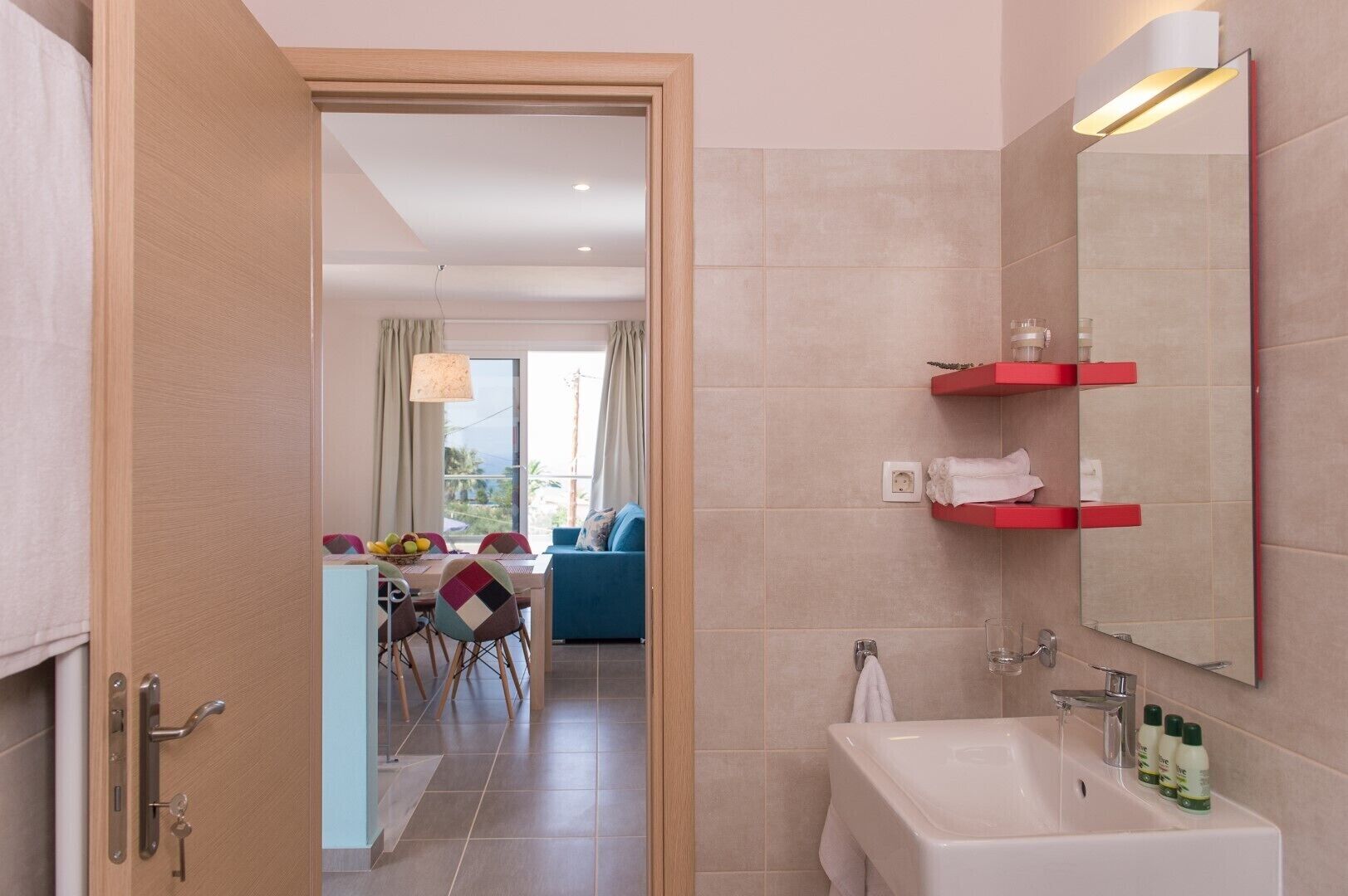 Une salle de bain moderne avec un lavabo, un miroir et des étagères rouges.