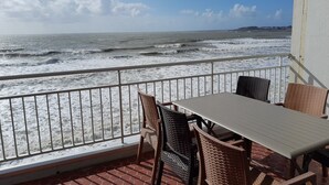 A balcony with a table and chairs overlooking the ocean. - Flat for 6 on the main beach, St Gilles (Saint-Gilles-Croix-de-Vie)