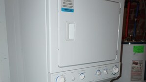 Eine kompakte, weiße Waschmaschine mit einer Bedienkonsole, die mehrere Regler und ein kleines Display aufweist.