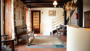 Un intérieur traditionnel avec des meubles en bois, un escalier et un porte-chapeaux mural.