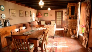 Une salle à manger traditionnelle avec une table et des chaises en bois, un canapé et une cheminée.