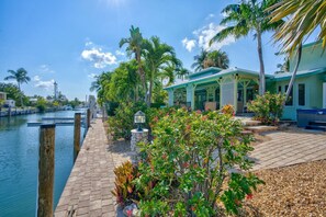 Enjoy a serene waterfront retreat with a beautifully maintained garden and a covered outdoor seating area.