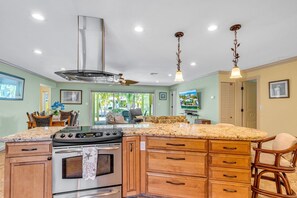 Enjoy cooking in this well-equipped kitchen with a large island, oven, and ample cabinetry.