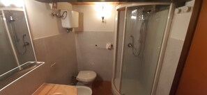 Ein kleines Badezimmer mit Toilette, Duschkabine und Waschbecken.