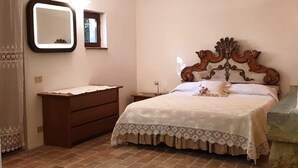 Ein Schlafzimmer mit einem Bett, einem Schminktisch und zwei Spiegeln an der Wand.