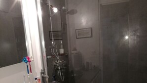 A modern bathroom with a large mirror, a black sink, and a shower area. - Bohemian chic apartment in the heart of the Antigone district (Montpellier)