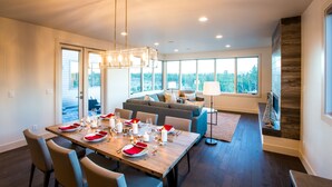Un comedor moderno con una mesa de madera para seis personas, un sofá y una chimenea.