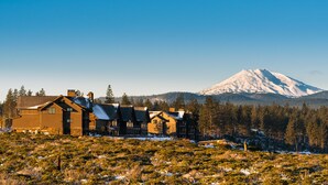 Una cabaña con varias cabañas más y una montaña al fondo.