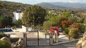 A gated property with a pool, surrounded by lush greenery and mountains in the background. - Villa Helios with Private Pool,New outside kitchen and BBQ,  welcome pack inc... (Kalathos)