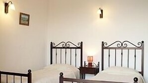 A room with two single beds, each with a wooden frame and white bedding. There are wall-mounted light fixtures on either side of the beds. - Villa Helios with Private Pool,New outside kitchen and BBQ,  welcome pack inc... (Kalathos)