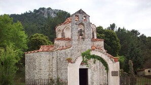 A small, rustic church with a bell tower, surrounded by greenery and a stone wall. - Villa Helios with Private Pool,New outside kitchen and BBQ,  welcome pack inc... (Kalathos)