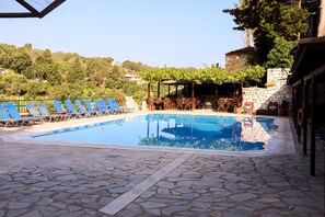 Een seizoensgebonden buitenzwembad, parasols voor strand/zwembad