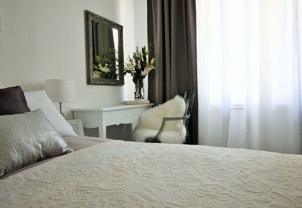 A neatly arranged hotel room with a large bed, a chair, a desk with a lamp, and a mirror. - Split Centre VIVERE Apartment (Split)
