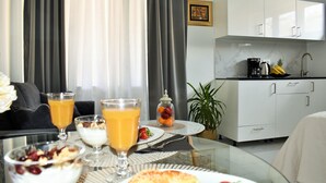 A modern kitchen with white cabinets, a coffee maker, and a fruit bowl. - Split Centre VIVERE Apartment (Split)