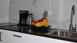 A kitchen with a marble backsplash, a coffee maker, a fruit bowl, and a stainless steel sink. - Split Centre VIVERE Apartment (Split)