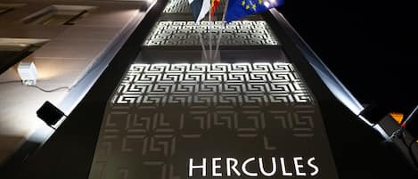 Señal del Hercules Boutique Hotel con un diseño geométrico y banderas.