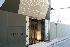 La entrada al Hercules Boutique Hotel, con un diseño geométrico y acceso visible.